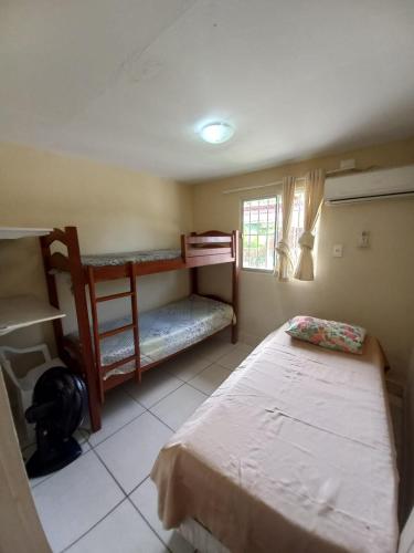 a bedroom with two bunk beds and a window at Condomínio da Barra - Chalé 6B in Tamandaré