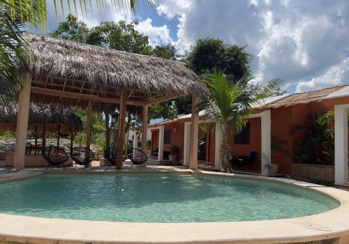 a swimming pool in front of a house at CASA VICTORIA in Chichén-Itzá