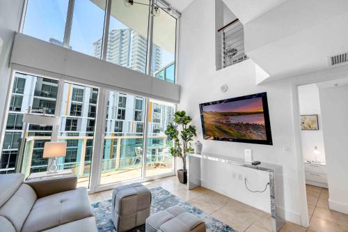 a living room with a couch and a flat screen tv at *Spacious 2BR Loft Brickell W/Stunning Views* in Miami