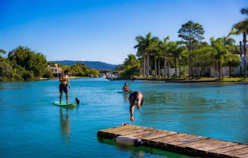 a group of people on a paddle board in the water at Nômades Adventure Hostel & Coworking in Florianópolis