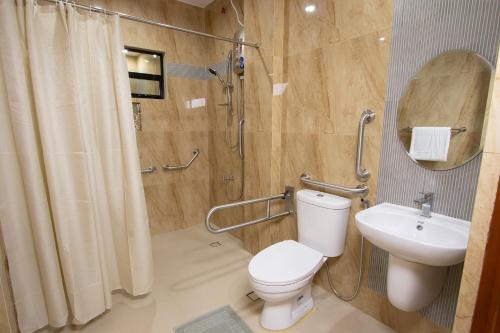 ein Bad mit einem WC, einer Dusche und einem Waschbecken in der Unterkunft Dancels Inn in Ormoc City
