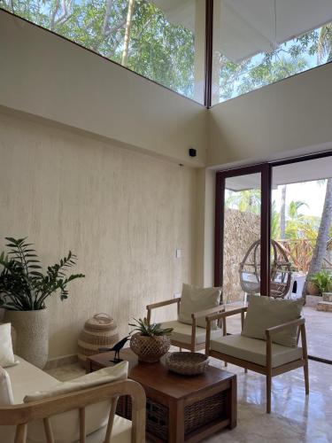 een woonkamer met stoelen en een tafel en ramen bij Tubará Casa de Playa in San Antero