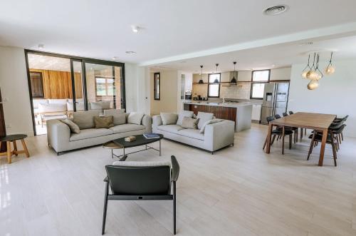 a living room with couches and a table and a kitchen at Estancia Santa Cruz in José Ignacio
