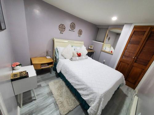 una camera da letto con letto, lenzuola e cuscini bianchi di Lovely 2 bedroom unit in private home a University Heights