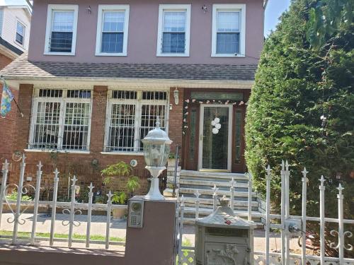 a house with a fence and a lamp in front of it at Lovely 2 bedroom Apartment with 2 Entrance and Parking in University Heights