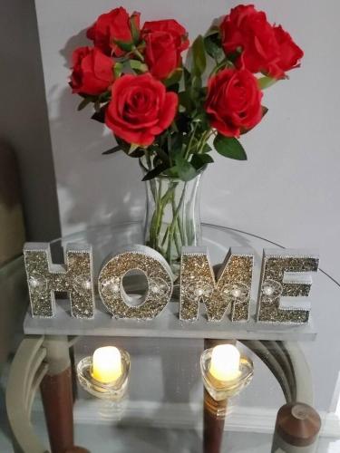 a vase of red roses and candles on a table with the wordvae at Lovely 2 bedroom Apartment with 2 Entrance and Parking in University Heights