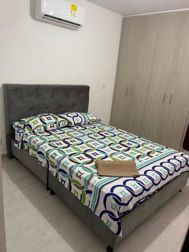 ein Schlafzimmer mit einem Bett mit einer bunten Bettdecke in der Unterkunft Apartamento Santafe cartago V in Marinita