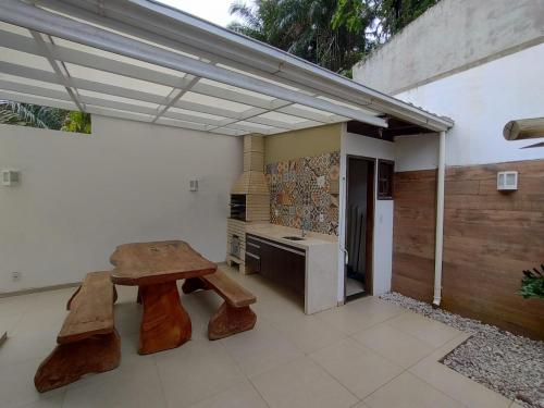 a patio with a wooden bench and a table at Village Praia Dourada - Praia dos Milionários in Ilhéus