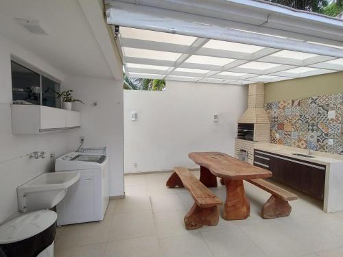 a bathroom with a bench and a sink and a toilet at Village Praia Dourada - Praia dos Milionários in Ilhéus