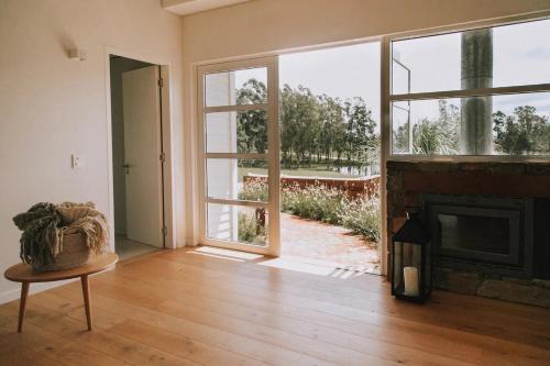 a living room with a fireplace and a large window at Estancia Santa Cruz in José Ignacio
