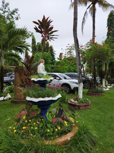 osoba siedząca w ogrodzie z kwiatami i palmami w obiekcie Villa Las Catalinas. Palaya Coronado. w mieście Playa Coronado