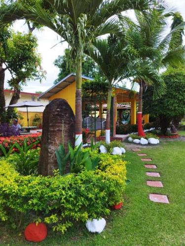 ogród z palmami i kwiatami przed budynkiem w obiekcie Villa Las Catalinas. Palaya Coronado. w mieście Playa Coronado
