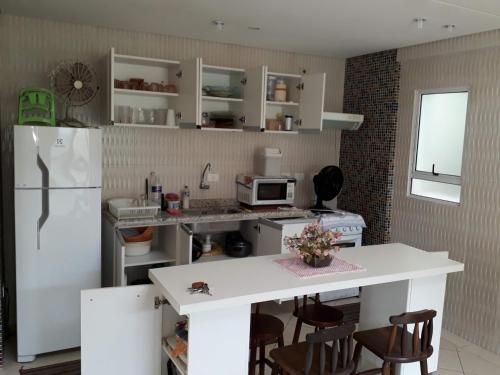 a kitchen with a white refrigerator and a white counter top at SOBRADO-BERTIOGA-Uso exclusivo para grupos de até 12 pessoas em 1 até 4 suítes in Bertioga