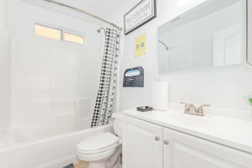 a white bathroom with a toilet and a sink at Vernon House - Stunning Cozy Vacation Home Near State Farm Stadium with Gym-Kitchen-Free Parking in Phoenix