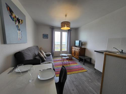un salon avec un canapé et une table dans une pièce dans l'établissement Appartement T2 rénové face mer avec balcon, à 150m de la plage et 300m des commerces - FR-1-92-611, à Les Sables-dʼOlonne
