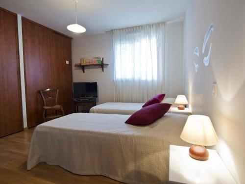 レ・サ​​ーブル・ドロンヌにあるAppartement Les Sables-d'Olonne, 4 pièces, 6 personnes - FR-1-92-590のベッド2台とテレビが備わるホテルルームです。