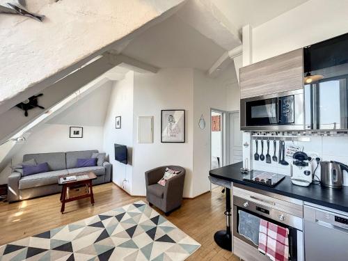 une cuisine et un salon avec un canapé et une table dans l'établissement Appartement cosy, 200m plage, parking privé, WiFi - FR-1-361-18, à Granville