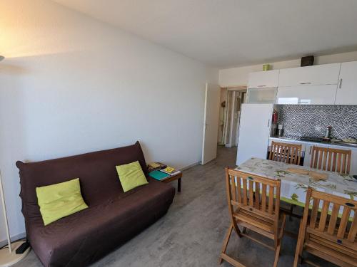 un salon avec un canapé et une table et une cuisine dans l'établissement T2 cabine 35m2 au port d'Arcachon avec balcon et parking sécurisé - FR-1-420-28, à Arcachon