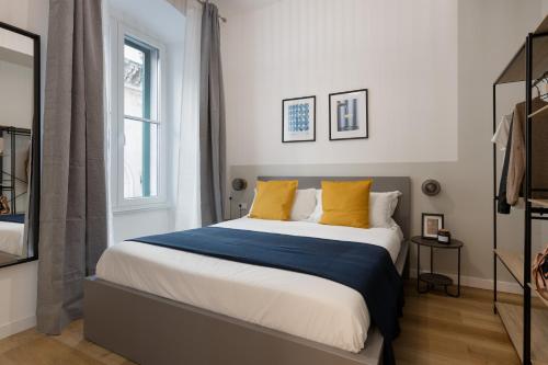 1 dormitorio con 1 cama grande con almohadas amarillas en Trieste Timeless 2-bedrooms flat, en Trieste