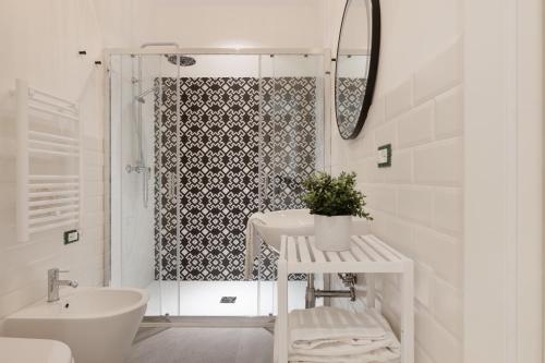 baño blanco con ducha y lavamanos en Trieste Timeless 2-bedrooms flat, en Trieste