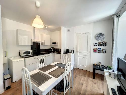 une cuisine et une salle à manger avec une table et des chaises dans l'établissement Appartement cosy avec ascenseur à 150m de la plage et casino, wifi gratuit - FR-1-361-330, à Granville
