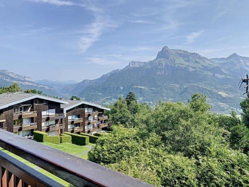 - une vue sur un hôtel avec des montagnes en arrière-plan dans l'établissement Studio confortable au centre de Combloux avec parking et accès ski bus - FR-1-560-35, à Combloux