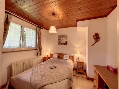 - une chambre avec un lit dans une pièce dotée de plafonds en bois dans l'établissement Appartement Combloux, 3 pièces, 6 personnes - FR-1-560-52, à Combloux