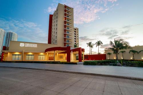 a large building with palm trees in front of it at Camino Real Veracruz in Veracruz