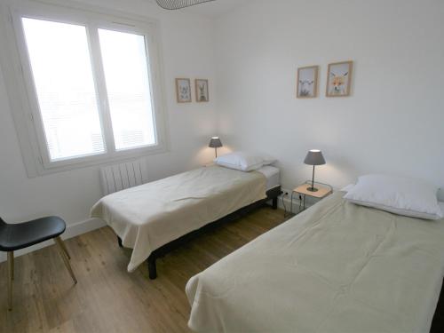 2 Betten in einem weißen Zimmer mit 2 Fenstern in der Unterkunft Maison La Tranche-sur-Mer, 3 pièces, 4 personnes - FR-1-22-322 in La Tranche-sur-Mer
