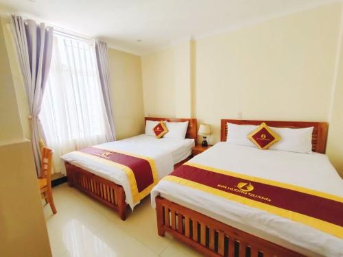 ein Hotelzimmer mit 2 Betten und einem Fenster in der Unterkunft Kim Huong Quang Hotel in Phu Quoc