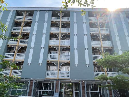 um edifício de apartamentos com varandas azuis e brancas em Burapha Bangsaen Garden Apartment em Bangsaen