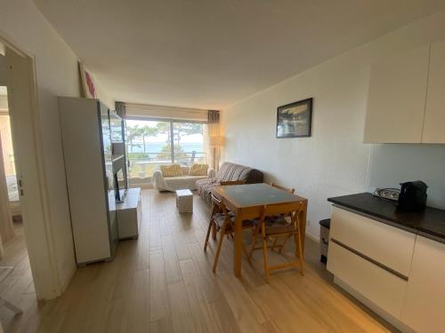 Il comprend une cuisine et un salon avec une table. dans l'établissement Appartement T2 bis avec balcon, parking et WIFI à Arcachon - FR-1-374-199, à Arcachon