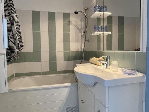 une salle de bain avec un lavabo et une baignoire dans l'établissement Appartement 2 pièces avec piscine proche commerces - FR-1-748-4, à Canet