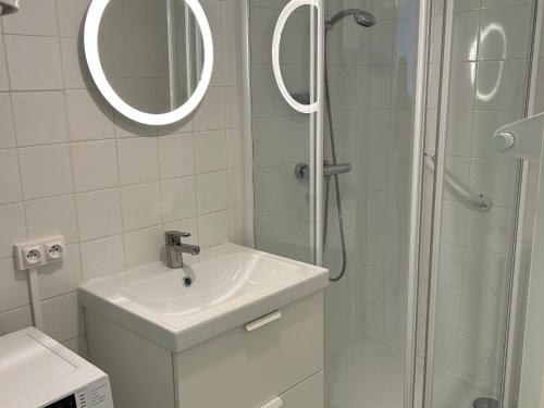 une salle de bain avec un lavabo et une douche avec un miroir dans l'établissement Appartement 1 chambre front de mer avec balcon et parking à St Hilaire de Riez - FR-1-652-38, à Saint-Hilaire-de-Riez