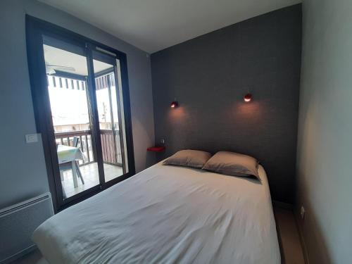 a bedroom with a large bed with a window at Appartement T2 Tout Confort Centre-Ville Vieux-Boucau avec Parking Privatif et Proche des Plages - FR-1-239-926 in Vieux-Boucau-les-Bains