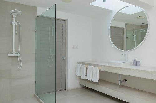 a bathroom with a shower and a sink and a mirror at Casa con vista a la bahía in Acapulco