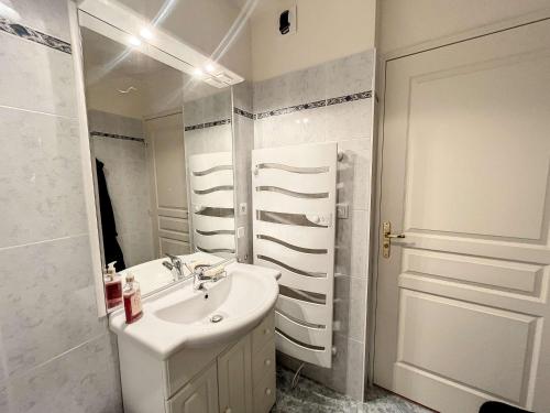 une salle de bain blanche avec un lavabo et un miroir dans l'établissement Appartement 2 chambres près de la plage avec balcon, ascenseur, garage et Wi-Fi gratuit - FR-1-361-487, à Granville