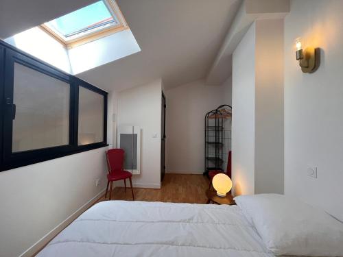 1 Schlafzimmer mit 2 Betten, einem Fenster und einem roten Stuhl in der Unterkunft Appartement Saint-Jean-de-Luz, 2 pièces, 4 personnes - FR-1-239-974 in Saint-Jean-de-Luz