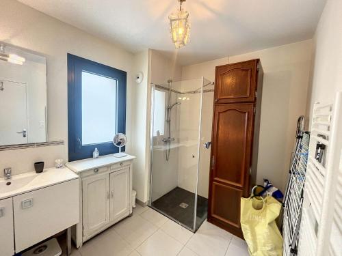 une salle de bain avec une douche, un lavabo et un miroir dans l'établissement Appartement PMR avec Terrasse au Cœur de Granville, Proche Plage et Port - FR-1-361-508, à Granville