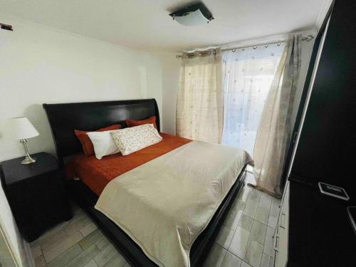 1 dormitorio con cama y ventana en Casa Aislada Peñaflor-Malloco, en Santiago