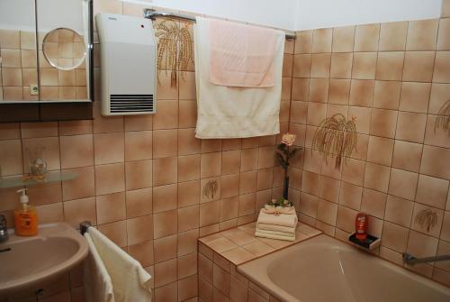 a bathroom with a tub and a sink and towels at Hotel Waldschloss in Bad Camberg