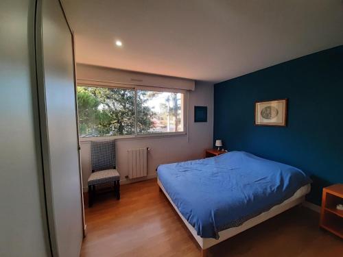 um quarto com paredes azuis, uma cama e uma janela em Maison Capbreton, 6 pièces, 11 personnes - FR-1-239-1001 em Capbreton