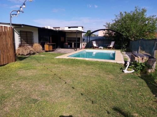 a backyard with a swimming pool in the grass at El séptimo día, lugar de descanso in Funes