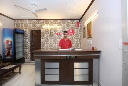 un homme debout dans un bar dans une pièce dans l'établissement OYO Flagship Hotel Sangam 45, à Chandigarh