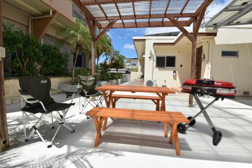 a patio with a picnic table and a grill at Seven Residence Music in Nago