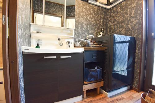 a small kitchen with a sink and a sink at Seven Residence Music in Nago