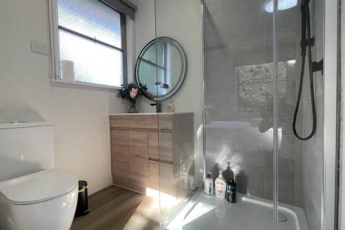 モーウェルにあるMorwell Pet friendly 3BR Retreat Free Parking Netflixのバスルーム(シャワー、トイレ、鏡付)