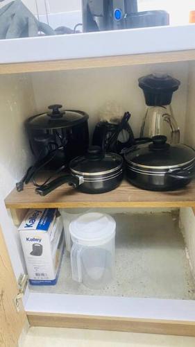 a shelf with pots and pans and a coffee maker at Casa de Descanso en Medellín in Medellín