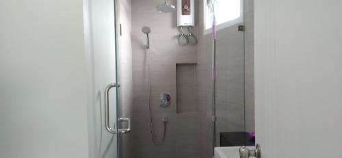 a bathroom with a shower with a glass door at วิวสระว่ายน้ำและทะเลสาบ 3ห้องนอน 2ห้องน้ำ in Ban Tha Fat