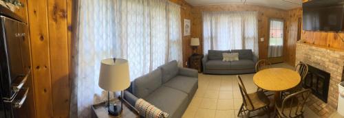 uma sala de estar com um sofá e uma mesa em South Shore Resort - The Blue Jay em Twin Lake